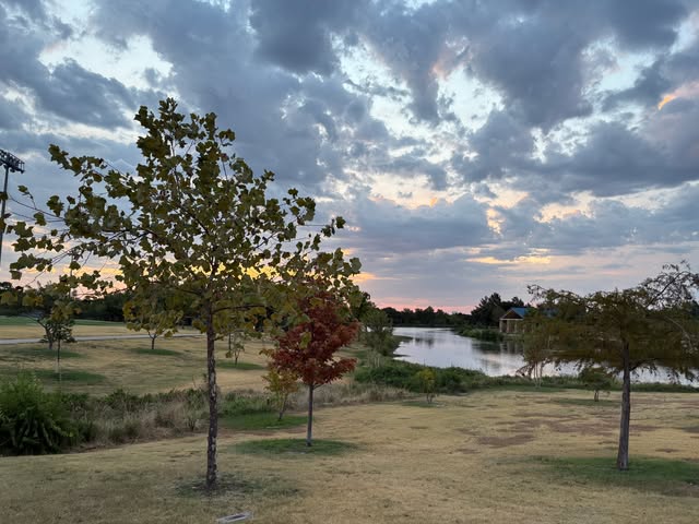 A park and pond in North Texas under a cloudy evening sky